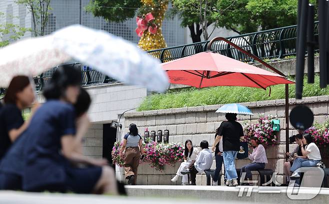 26일 오후 서울 청계광장에서 양산을 쓴 시민들이 올해 마지막 봄을 즐기고 있다. 기상청은 내일과 모레 동쪽 지방을 중심으로 요란한 소나기가 지나가고 주 후반에는 30도 안팎의 더위가 나타날 것으로 예보했다. 2025.5.26/뉴스1 ⓒ News1 신웅수 기자