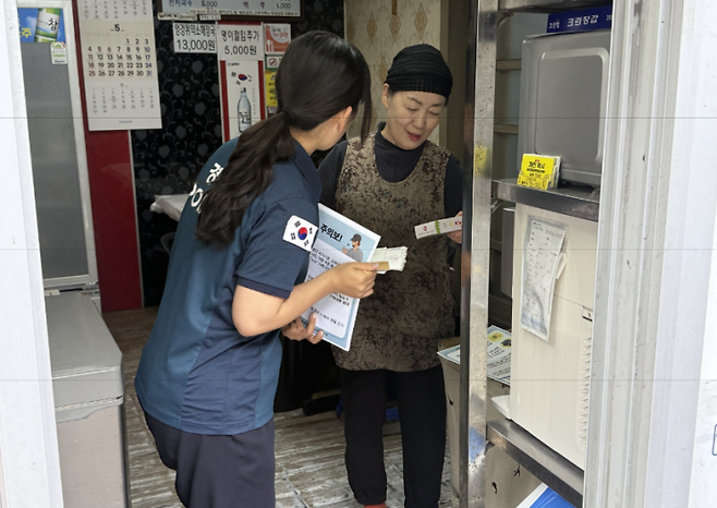 경찰관이 직접 홍보 전단을 들고 인근 상인들을 찾아 노쇼 예방 교육을 하고 있다. 울릉경찰서 제공