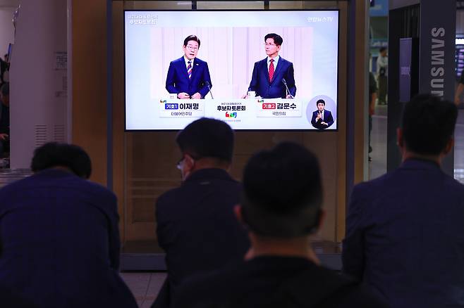 제21대 대통령선거 후보 정치분야 TV토론회가 열린 27일 서울역 대합실에서 시민들이 토론회 중계방송을 지켜보고 있다. /연합뉴스