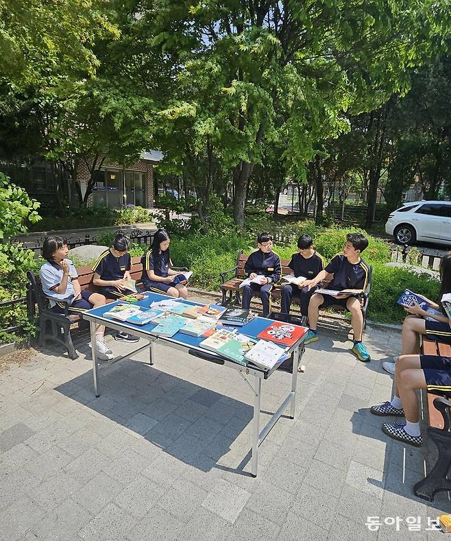 구룡중의 생태교육 주간 아침에 양재천 주변을 뛴 학생들이 벤치에 앉아 체육, 스포츠 관련 책을 보면서 자유롭게 토론하고 있다. 유재영 기자 elegant@donga.com