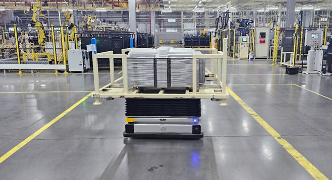 구영테크 생산현장 내부에서 프레스품 용접 설비로 이송하는 모습.