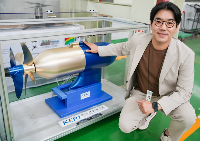한국전기연구원 전동력연구센터 홍도관 박사가 50kW급 비접촉 마그네틱 기어 적용 상반회전 프로펠러 앞에서 포즈를 취했다.