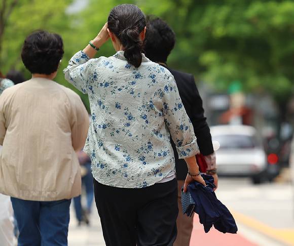 지난 20일 서울 청계천에서 시민들이 외투를 팔에 걸고 산책을 즐기고 있다. [사진=연합뉴스]