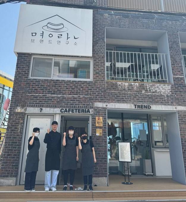 부산 동구 초량동에 있는 ‘명란브랜드연구소’ 앞에서 직원들이 파이팅 포즈를 취해 보이고 있다. 동구청 제공