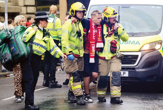영국 머지사이드주 리버풀 워터스트리트에서 26일(현지시간) 차량 돌진 사고로 다친 축구팬을 구조대원들이 옮기고 있다. AP연합뉴스