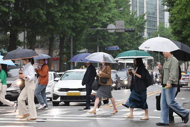 15일 서울 광화문 부근에서 시민들이 우산을 쓰고 이동하고 있다. [사진 출처 = 연합뉴스]
