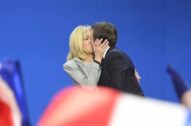 에마뉘엘 마크롱 프랑스 대통령(오른쪽)이 부인 브리지트 마크롱 여사와 입을 맞추고 있다. [AFP]