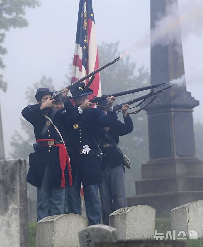 [존스타운=AP/뉴시스] 26일(현지 시간) 미 펜실베이니아주 존스타운의 그랜드뷰 묘지에서 제54 펜실베이니아 자원보병연대 A중대 대원들이 남북전쟁 북군 참전용사 제이컵 캠벨 대령을 기리는 예총을 발사하고 있다. 2025.05.27.