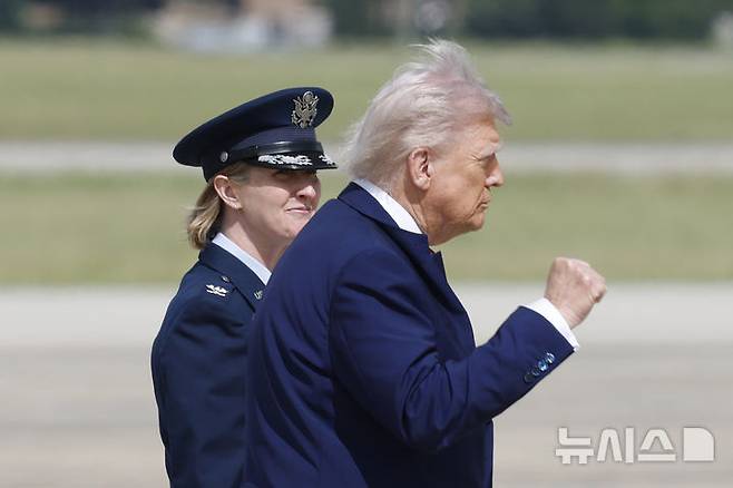 [앤드루스 공군기지=AP/뉴시스]도널드 트럼프 미 대통령이 지난 23일(현지시각) 앤드루스 공군기지에서 전용 헬기에서 내려 전용기에 탑승하러 이동하고 있다. 옆은 89수송편대장 앤젤라 오초아 대령이다. 트럼프가 흑인과 여성 등 소수자 차별 조사에 집중하던 인권기관들로 하여금 백인 권리 신장에 몰두하도록 지시하고 있다. 2025.5.27.