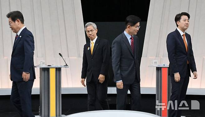 [서울=뉴시스] 국회사진기자단 = 27일 오후 서울 마포구 상암동 MBC 스튜디오에서 열린 중앙선거방송토론위원회 주관 제21대 대통령선거 3차 후보자토론회 시작에 앞서 각 정당 대선후보들이 기념촬영을 마친 뒤 자리로 돌아가고 있다. 왼쪽부터 이재명 더불어민주당, 권영국 민주노동당, 김문수 국민의힘, 이준석 개혁신당 대선후보. 2025.05.27. photo@newsis.com