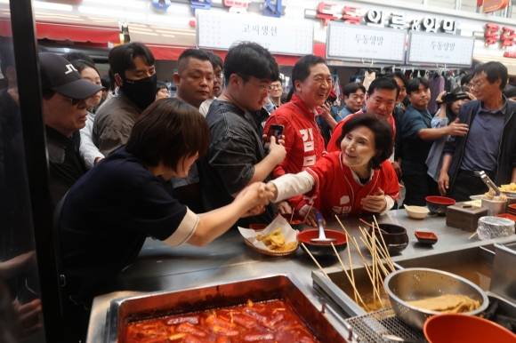 시장 훑고 - 김문수 국민의힘 대선 후보의 배우자 설난영(앞줄 오른쪽)씨가 26일 울산 수암시장을 찾아 시민과 악수하고 있다. 국민의힘 제공