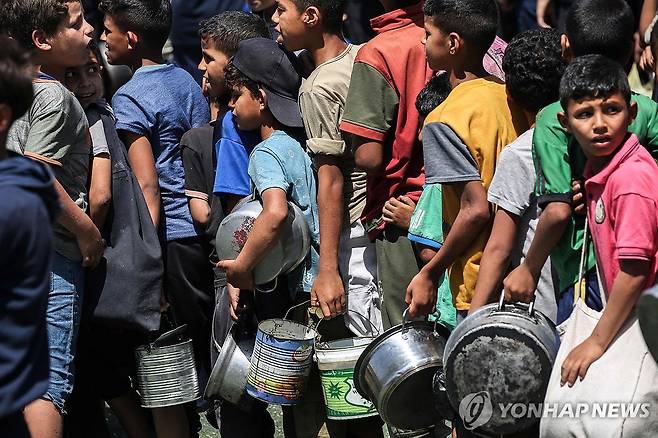 배식 기다리는 가자지구 어린이들 (누세이라트 AFP=연합뉴스) 지난 24일(현지시간) 가자지구 누세이라트 난민촌의 팔레스타인 어린이들이 배식을 기다리며 줄을 서 있다. 2025.5.26 photo@yna.co.kr