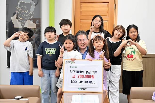 지난 27일 군위군 효령면 젬베동아리 어린이들이 어려운 이웃을 위해 공연비 20만 원을 기부하며 지역에 훈훈한 감동을 전했다(젬배동아리 어린이들과 김진열 군위군수). /대구 군위군 제공