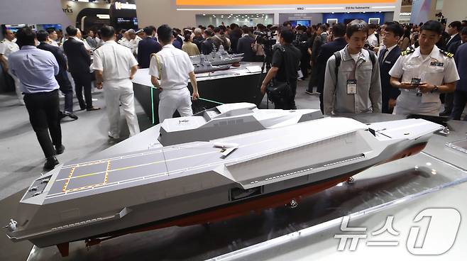 28일 부산 해운대구 벡스코 제1전시장에서 열린 '2025 국제해양방위산업전(MADEX)'에서 참가자들이 HD현대중공업 부스를 찾아 미래형 무인전력모함 등을 살펴보고 있다.  2025.5.28/뉴스1 ⓒ News1 윤일지 기자