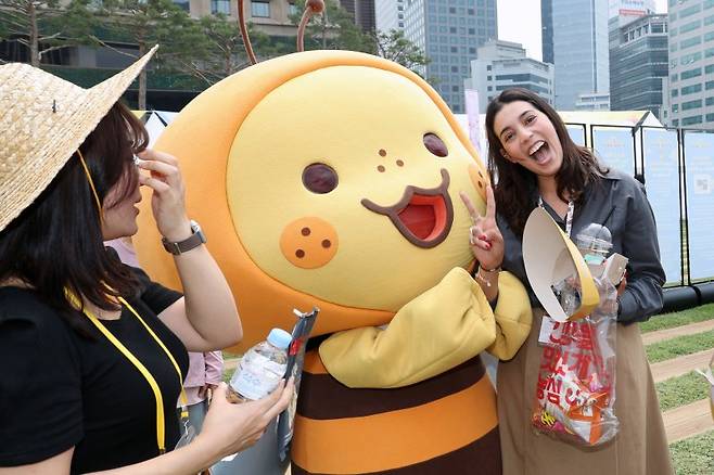 28일 서울 중구 서울광장에서 열린 2025 서울식품유통대전(K푸드쇼)을 찾은 여성 외국인이 K스낵 기업의 캐릭터와 환한 표정으로 포즈를 취하고 있다. 사진=서동일 기자