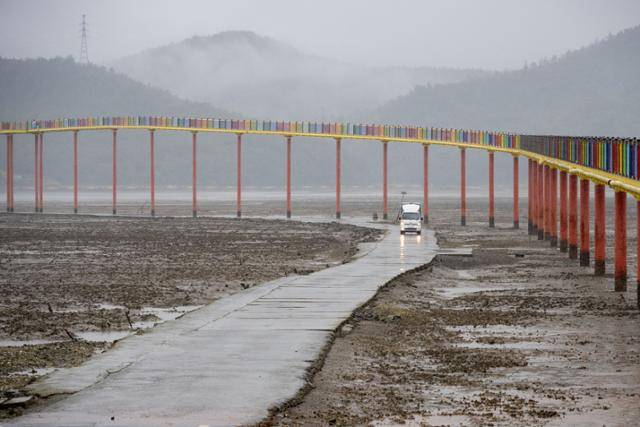 우도의 노둣길로 화물 차량이 지나고 있다. 뒤로 보이는 것이 새로 놓인 보행교.