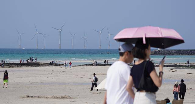맑은 날씨를 보인 25일 오후 제주시 한림읍 협재해수욕장을 찾은 관광객들이 때 이른 여름 정취를 만끽하고 있다. 뉴시스