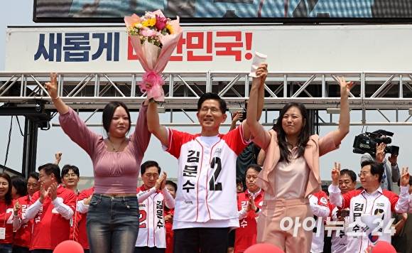 김문수 국민의힘 대통령 후보가 28일 경남 김해를 찾아 지지자로부터 꽃다발을 받고 두 팔을 들어 인사하고 있다. [사진=임승제 기자]