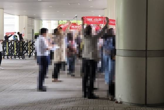 26일 윤석열 전 대통령이 오후 재판을 위해 법원 청사 서관 입구에 도착하자 지지자들이 일제히 붉은 수건을 펴보이며 "윤석열!" "대통령!"을 외치는 모습. 김정연 기자