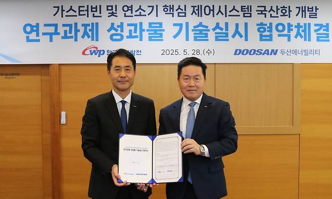 손승우 두산에너빌리티 파워서비스 부사장과 엄경일 기술안전부사장이 협약식 후 기념 촬영을 하고 있다. [사진 = 한국서부발전]