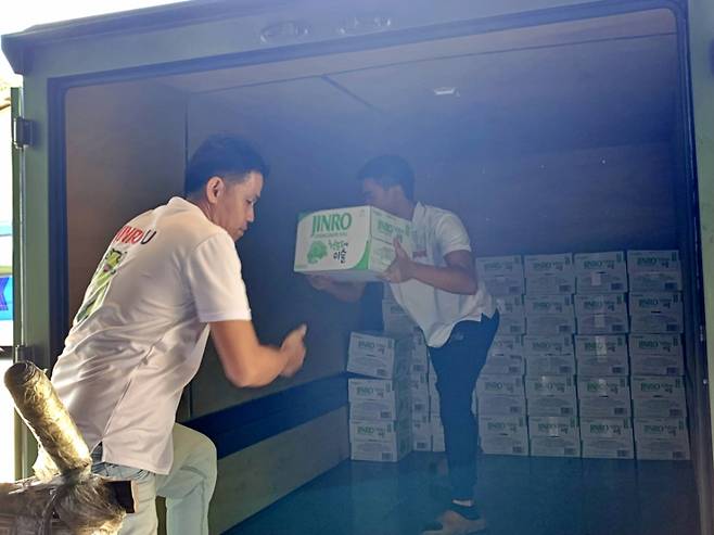 지난 19일 하이트진로의 필리핀 현지 거래처 K&L 직원들이 차량에 ‘진로(JINRO)’ 제품을 적재하고 있다./사진제공=하이트진로