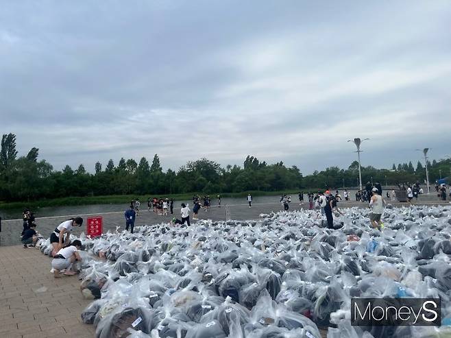 지난 24일 서울 마포구 평화의공원에서 열린 ‘제30회 바다의날 마라톤’에서 참가자들이 비닐 포장된 개인 짐을 물품보관소에 맡기고 있다. 이 대회는 해상 안전과 깨끗한 해양 환경의 중요성을 알리기 위해 매년 5월31일 바다의날을 맞아 개최된다. /사진=김대영 기자