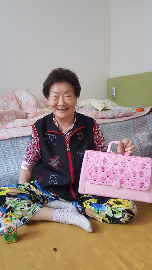 고 심순애 씨가 2017년 선물로 받은 가방을 들고 환하게 웃어 보이고 있다.  초록우산 제공