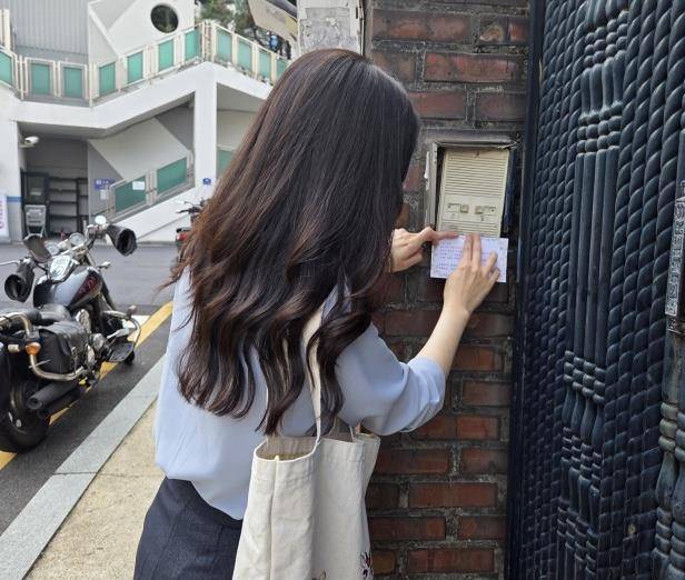 26일 용산구청 직원이 부재중인 환급 대상자 어르신 가정 초인종에 환급 안내문을 부착하고 있다. 사진제공=용산구