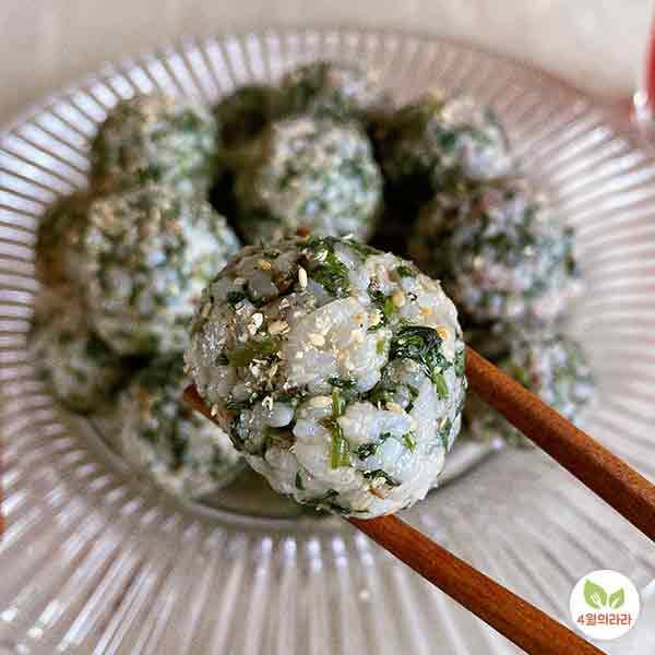 쑥주먹밥 하나를 든 모습