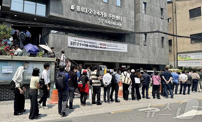 제21대 대통령선거 사전투표 첫 날인 29일 서울 종로구 종로1·2·3·4가동 주민센터 투표소에 마련된 투표소에서 직장인들이 점심시간을 이용해 투표를 위해 길게 줄을 늘어서 있다. 사전투표 첫날 오후 1시 기준 전국 평균 투표율은 지난 20대 대선(36.93%)의 같은 시각 투표율(8.75%)보다 1.76% 높은 10.51%로 역대 최고치다. 2025.5.29/뉴스1 ⓒ News1 유승관 기자