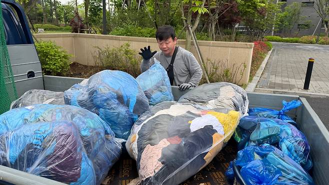 김영선씨가 트럭에 헌옷이 담긴 비닐봉지를 담고 있다./김도균 기자