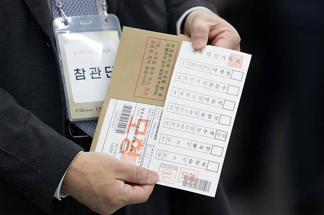 제21대 대통령 선거 사전투표를 하루 앞둔 28일 서울 광진구 중곡3동 주민센터에 마련된 사전투표소에서 투표 참관단이 인쇄된 투표용지를 들어보이고 있다.  2025.05.28. 사진공동취재단