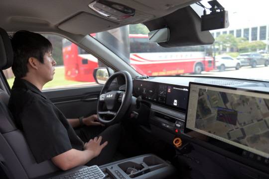 ETRI 자율주행 연구차량에 탑승한 운전자가 운전대 조작 없이 주행하고 있다.