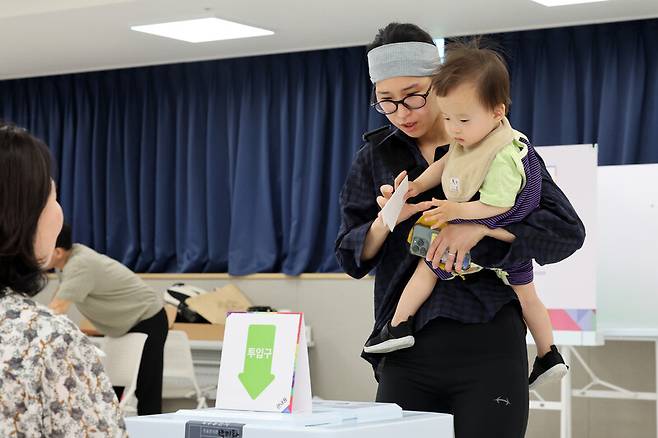 제21대 대통령선거 사전투표 첫날인 29일 오전 경기 화성시 동탄9동 행정복지센터에서 유권자가 아이와 함께 투표함에 투표용지를 넣고 있다. 김영원 기자 forever@hani.co.kr