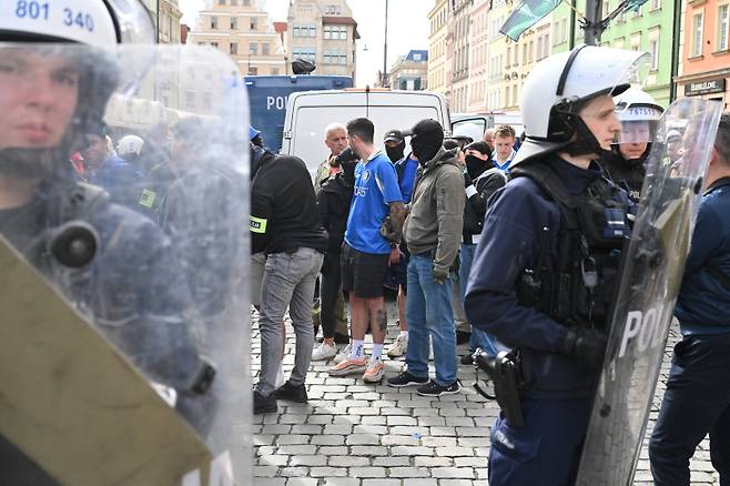 <yonhap photo-1191=""> epa12141312 Supporters of Chelsea surrounded by Polish police officers stand at the Market Square in Wroclaw, after clashing with supporters of Real Betis, ahead of the UEFA Europa Conference League final soccer match between Real Betis and Chelsea FC, in Wroclaw, Poland, 28 May 2025. EPA/Maciej Kulczynski POLAND OUT/2025-05-29 04:45:14/ <저작권자 ⓒ 1980-2025 ㈜연합뉴스. 무단 전재 재배포 금지, AI 학습 및 활용 금지></yonhap>