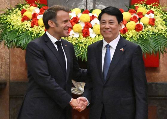원전 세일즈에 나선 에마뉘엘 마크롱 프랑스 대통령(왼쪽)이 26일 하노이 주석궁에서 르엉끄엉 베트남 국가주석과 악수하고 있다. 베트남은 원전 개발을 추진 중이다. [AP=연합뉴스]