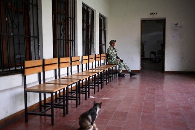 텅빈 투표소 베네수엘라 총선·지방선거가 25일(현지시간) 실시된 가운데 수도 카라카스에 마련된 텅 빈 투표소에서 군인 한 명이 한가롭게 경비를 서고 있다. 로이터연합뉴스