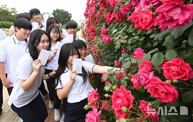 [수원=뉴시스] 김종택기자 = 제21대 대통령선거 사전투표 첫날인 29일 경기 수원시 연무동 행정복지센터에 마련된 사전투표소에서 삼일공업고등학교 3학년 학생 유권자들이 생애 첫 투표를 마친 뒤 장미꽃 앞에서 인증샷을 남기고 있다. 2025.05.29. jtk@newsis.com