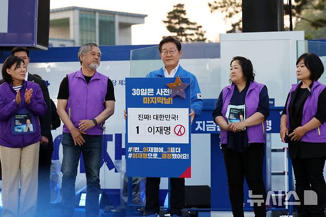 [서울=뉴시스] 조성우 기자 = 이재명 더불어민주당 대선후보가 29일 오후 관악구 관악산으뜸공원에서 열린 유세에서 이태원참사 유가족에게 '진실의 별'을 전달받고 있다. 2025.05.29. xconfind@newsis.com