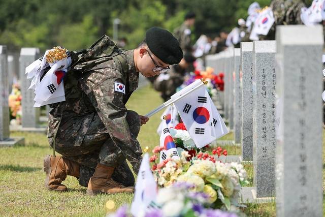 국방정신전력원 교직원과 교육생들이 27일 대전 유성구 국립대전현충원을 찾아 참배하고 순국선열 및 호국영령들의 묘비에 태극기를 꽂고 있다. 국방정신전력원
