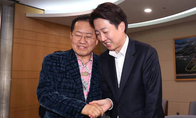 홍준표 전 대구시장이 지난 10일 오후 인천국제공항 제1여객터미널에서 미국 출국을 앞두고 배웅온 이준석 개혁신당 대선후보와 악수를 나누고 있다. 인천공항=뉴시스