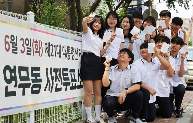 제21대 대통령선거 사전투표 첫날인 29일 경기도 수원시 장안구 연무동행정복지센터에 마련된 투표소에서 투표를 마친 삼일공업고등학교 3학년 학생들이 투표확인증을 들고 인증사진을 찍고 있다. 수원=연합뉴스