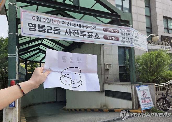 21대 대선 사전투표 인증샷 (수원=연합뉴스) 김솔 기자 = 21대 대통령선거 사전투표 첫날인 29일 경기도 수원 영통2동사전투표소 밖에서 한 유권자가 투표를 마친 뒤 투표 인증샷을 찍고 있다. 2025.5.29 sol@yna.co.kr