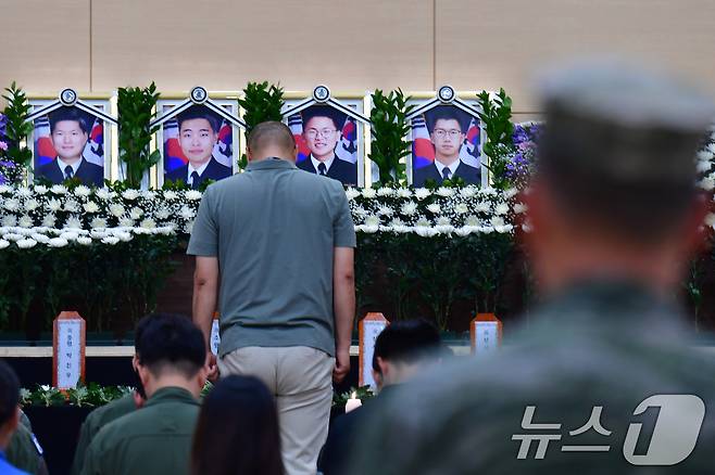 30일 경북 포항시 해군 항공사령부체육관에 마련된 대잠 해상초계기(P-3CK) 순직자 합동분향소에서 조문객이 묵념하고 있다. 해군은 고 박진우 중령, 고 이태훈 소령, 고 윤동규 상사, 고 강신원 상사로 1계급 추서했다. 2025.5.30/뉴스1 ⓒ News1 최창호 기자
