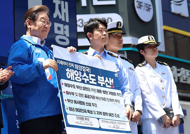 이재명 더불어민주당 대통령 후보가 민주당 험지로 꼽히는 부산·경남(PK) 지역 유세에 나선 14일 부산 부산진구 서면을 찾아 권기흥 에이치라인해운해상직원노조 위원장과 해양수도 부산 협약서에 서명한 뒤 기념촬영을 하고 있다./뉴스1