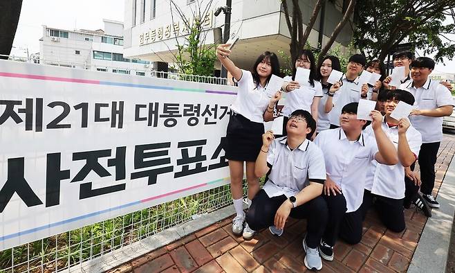 제21대 대통령선거 사전투표 첫날인 29일 경기도 수원시 장안구 연무동행정복지센터에 마련된 투표소에서 투표를 마친 삼일공업고등학교 3학년 학생들이 투표확인증을 들고 인증사진을 찍고 있다. 연합뉴스