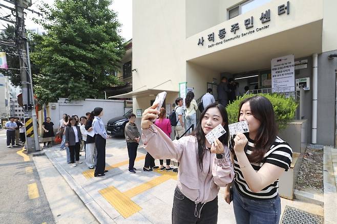 제21대 대통령 선거 사전 투표 둘째 날인 30일 서울 종로구 사직동주민센터에 마련된 사전투표소 앞에서 유권자들이 투표를 하고 인증 사진을 찍고 있다.