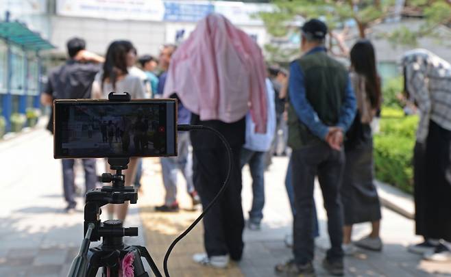 제21대 대통령 선거 사전 투표 둘째 날인 30일 오후 서울 강남구 역삼1동 주민센터에 마련된 사전투표소에서 부정선거 주장 단체 클린선거시민행동 회원들이 사전투표에 참여하는 시민들을 촬영하고 있다. /사진=뉴스1