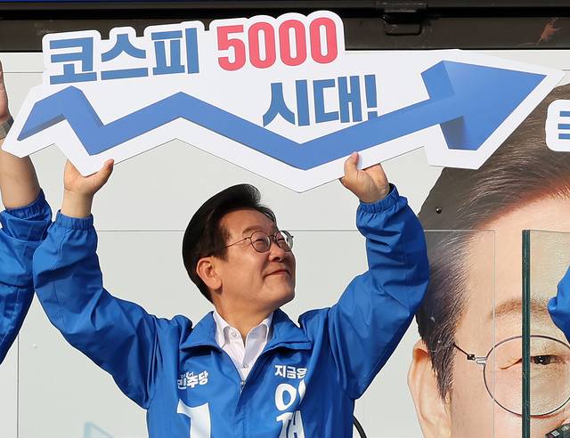 ‘경제 회복’ 메시지 이재명 더불어민주당 대통령 선거 후보가 29일 서울 서초구 서울고속버스터미널 광장에서 열린 유세에서 ‘코스피 5000시대’ 팻말을 들어보이고 있다.  뉴시스