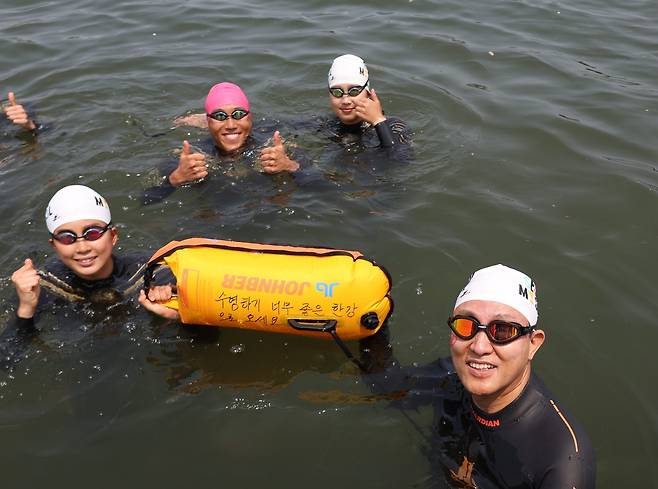 오세훈 서울시장이 30일 ‘쉬엄쉬엄 한강 3종 축제’ 1일차 수영종목에 출발 전 ‘수영하기 너무 좋은 한강으로 오세요 수질 환상적!’ 안전부이를 들고 도강을 준비하고 있다.. [서울시 제공]